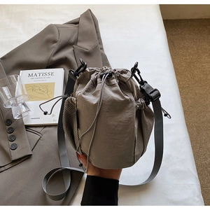 Detailansicht der grauen Nylon-Beuteltasche mit Netztasche auf weißem Stoff