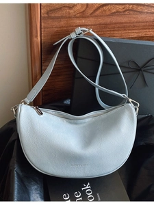 Light blue faux leather half-moon crossbody bag with adjustable strap and metal zipper