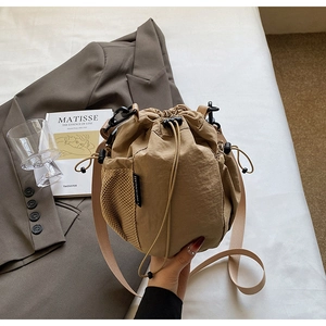 Detail einer khakifarbenen Kordelzug-Beuteltasche aus Nylon mit seitlicher Netztasche