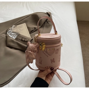Detail of pink barrel bag with teddy bear pattern, metal charms and adjustable shoulder strap