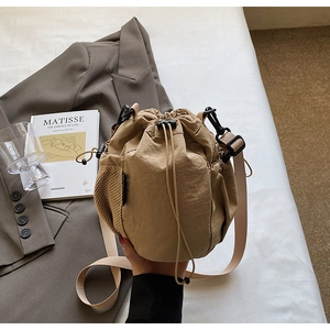Nahaufnahme der khakifarbenen Kordelzug-Beuteltasche mit Netzfach und verstellbarem Gurt
