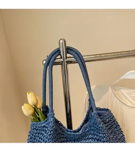 Detail of hand-woven navy blue straw tote bag with durable shoulder straps for summer beach