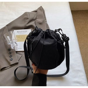 Detail der schwarzen Nylon-Beuteltasche mit Tunnelzug, Netzseitentasche und Trageriemen