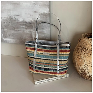 Macro detail of multicolored woven straw tote with silver eyelet shoulder strap texture