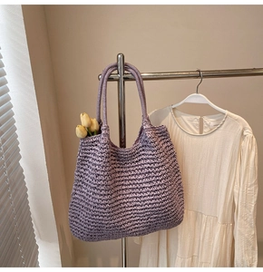 Détail d'un sac cabas violet en paille tressée à la main avec texture tricotée