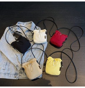 Detailed flat lay of mini canvas drawstring bucket bags in five vibrant colors