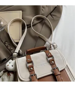 Detail of a retro color-block backpack with adjustable straps and a plush bear pendant