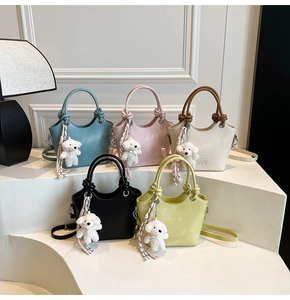 Détail de sacs seaux colorés en cuir PU avec breloques d'ours en peluche sur marches