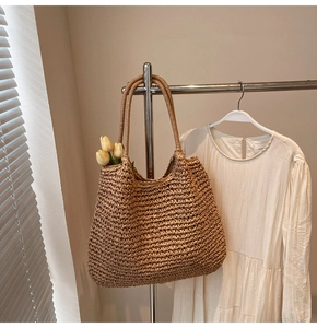 Détail du sac cabas en paille fait main avec texture tissée serrée et longues anses