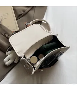 Interior view of cream-colored backpack showing spacious capacity for phone and cosmetics