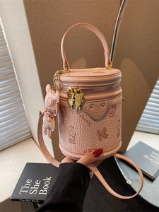 Pink lychee leather cylinder bucket bag with teddy bear pendant and gold bear zipper
