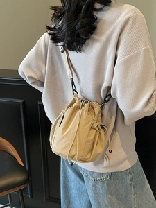 Minimalistische hellbraune Beuteltasche mit Kordelzug, Netzseitentasche und Gurt