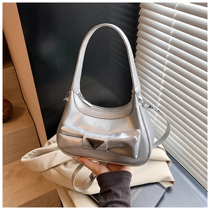 Detail of silver metallic handbag featuring large bow and textured brushed finish texture