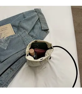 Internal view of cream canvas bucket bag showing capacity for phone and wallet