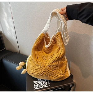 Close-up of handmade hollow crochet texture on yellow and white knit tote bag
