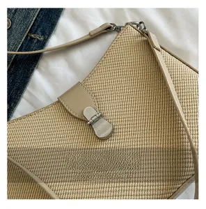 Close-up of woven straw texture and beige leather trim with a silver metal buckle
