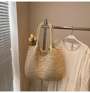 Détail d'un grand sac cabas en paille tressée à la main avec poignée ronde intégrée