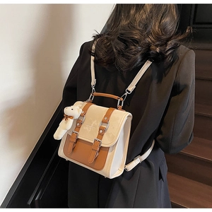 Close-up of stylish retro color-block backpack with cute bear pendant charm on model