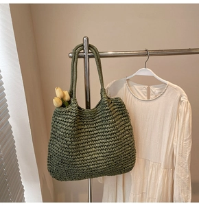 Vue détaillée du sac cabas en paille vert olive avec texture tissée et anses rondes