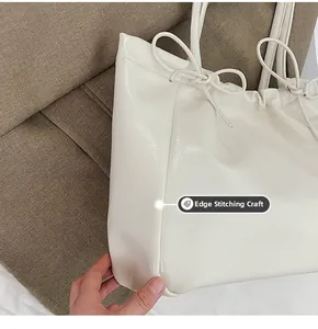 Détail de la finition des bords sur un grand sac cabas blanc en cuir souple pour femme