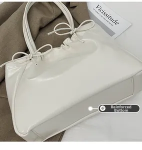 Détail du grand cabas blanc brillant avec fond renforcé et nœud décoratif en cuir