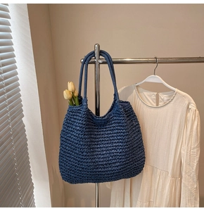 Vue détaillée de la texture du sac cabas en paille tressée bleu foncé et des anses