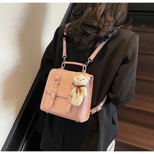 Detail of pink patent leather mini backpack with silver buckle and plush bear charm