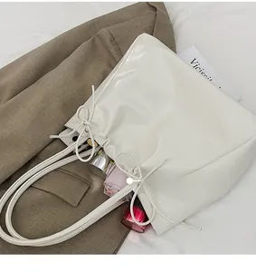 Vue détaillée du rangement intérieur du cabas en cuir verni blanc avec ses accessoires