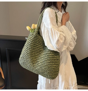 Close-up of a large green straw tote bag with hand-woven texture and yellow tulips