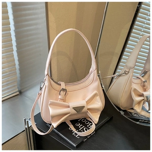Detailed mirror view of pink faux leather handbag with bow and metal triangle logo