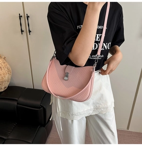 Pink crescent shoulder bag featuring textured woven pattern and matte silver buckle detail