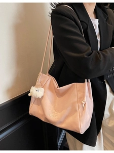 Pink faux leather tote bag with lychee texture and cute plush monster charm detail
