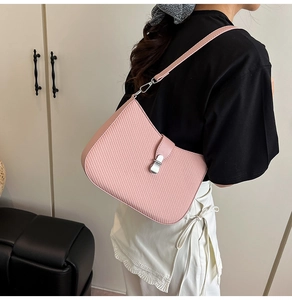 Close-up of pink woven texture shoulder bag with silver metal swivel clasp and leather strap