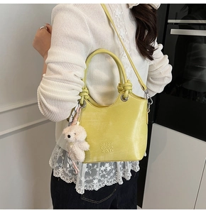 Détail du sac seau jaune moutarde avec poignée en corde et pendentif chien en peluche