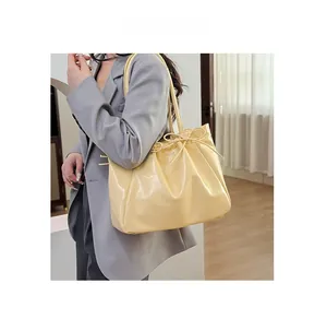 Détail d'un sac cabas en cuir crème avec un nœud coulissant élégant pour le quotidien