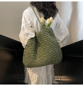 Détail du sac cabas en paille tissée verte avec texture fine et fines bandoulières