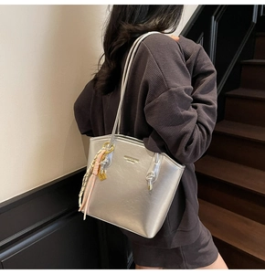 Dettaglio della borsa tote argento testurizzata con sciarpa di seta e logo goffrato