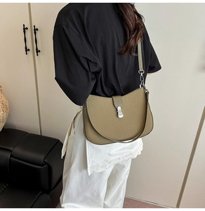 Detail view of olive green woven shoulder bag with silver clasp and leather trim