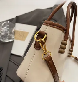 Detailed close-up of premium gold-toned hardware and contrast stitching on a stylish bucket bag