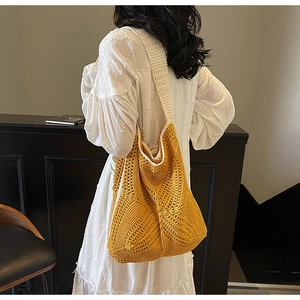 Detail of ginger woven hobo bag showing geometric hollow pattern and white strap