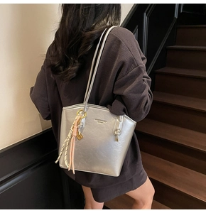 Dettaglio della borsa tote argento metallizzato con logo oro e corda intrecciata