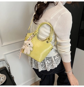 Détail du sac seau vert clair avec breloque ours en peluche et foulard floral