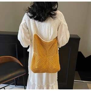 Close-up of ginger yellow crochet tote bag showing hollow star weave pattern and soft straps