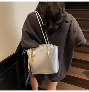 Borsa tote argento metallizzato con foulard chic su modella in ambiente vintage