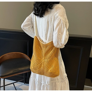 Detail view of mustard yellow crochet tote bag showing woven texture and wide shoulder strap