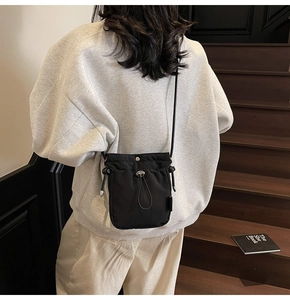 Detail of black nylon drawstring bucket bag with metal buckle and premium texture