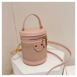 Dettaglio della borsa a secchiello cilindrica rosa con trama intrecciata e hardware dorato