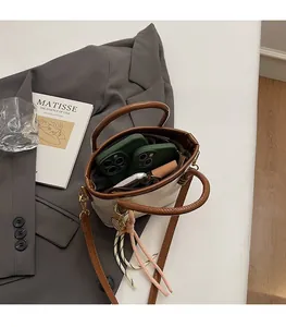 Top view showing the spacious interior of this beige bucket bag with brown handles