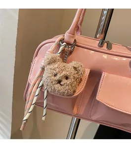 Nahaufnahme der rosa Boston Bag aus Lackleder mit süßem braunem Plüschbär-Anhänger