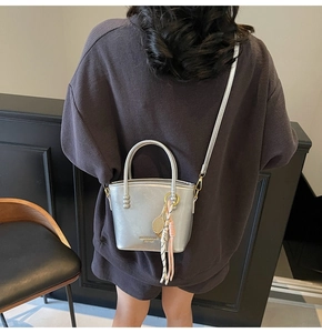Detailed back view of a silver mini tote bag with tennis racket charm and silk scarf decoration